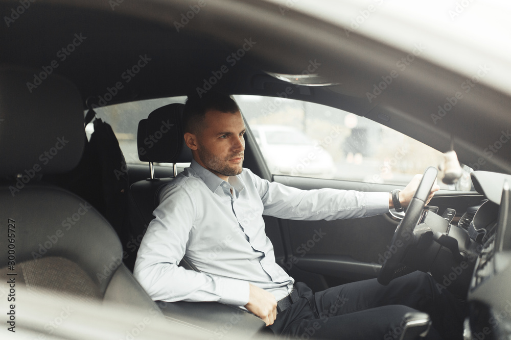 Conversations and phone calls, negotiations. Portrait of a young successful man in the car. Conversations and phone calls, negotiations. Portrait of a young successful man in the car.