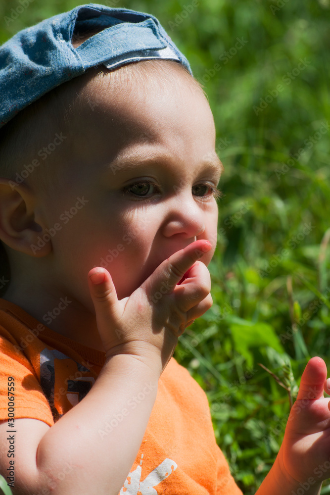 Blond-haired blue-eyed child eats berries in the garden. Blond-haired blue-eyed child eats berries in the garden.