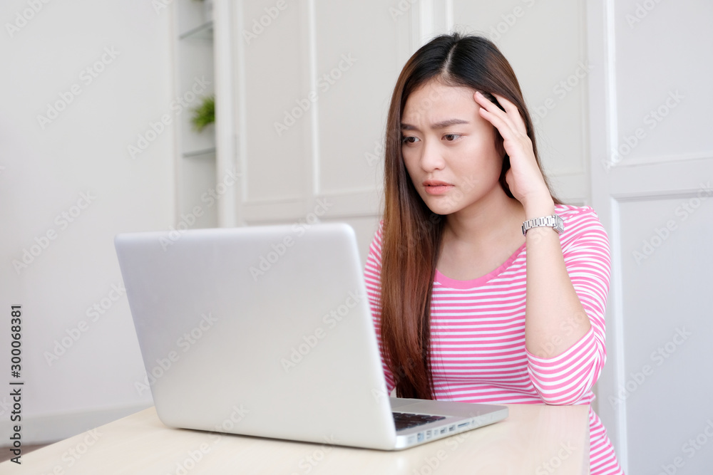 Young asian woman struggle with laptop computer, Frustrated asian girl looking at laptop while working at home, People struggle with technology Young asian woman struggle with laptop computer, Frustrated asian girl looking at laptop while working at home, People struggle with technology