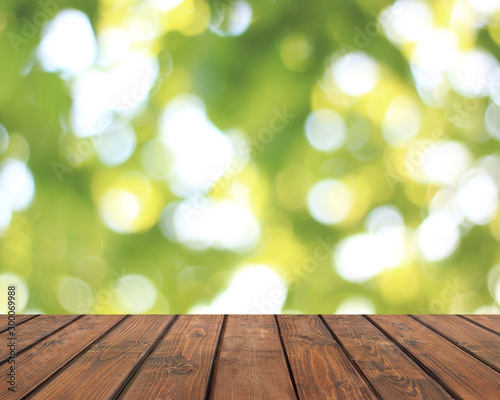 Empty wooden table on a summer blurred background.