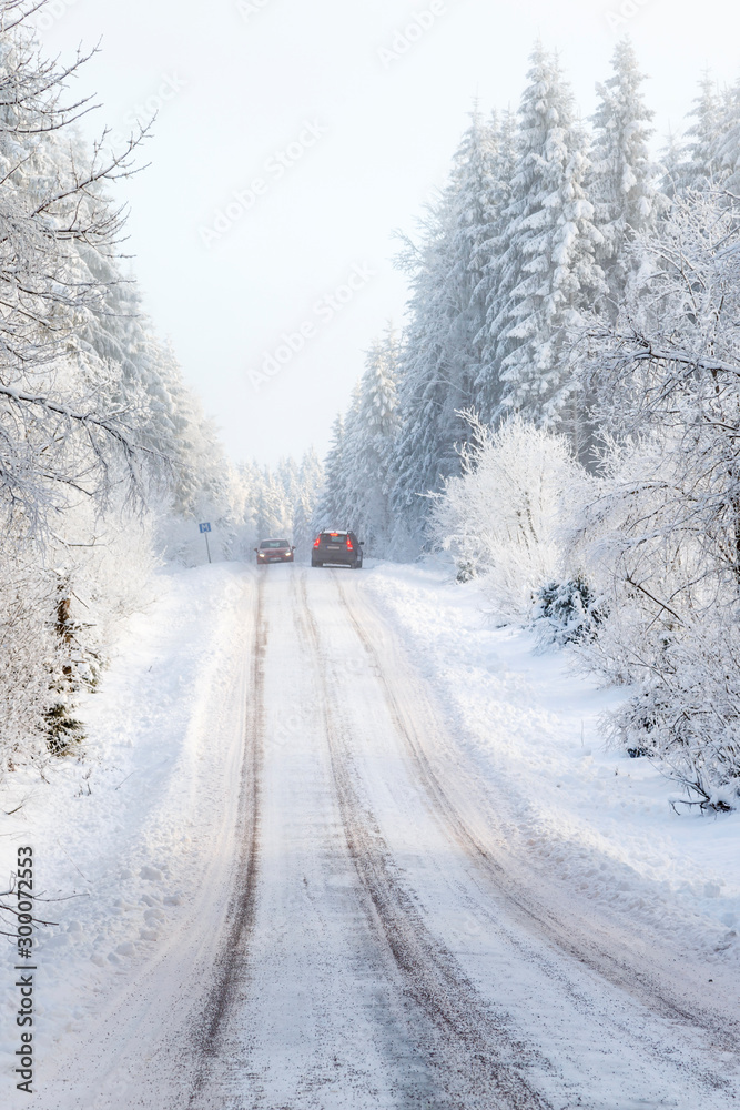 Two cars meeting on a narrow winter road in the forest Two cars meeting on a narrow winter road in the forest