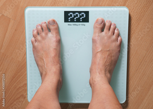 Healthy diet, fitness and weight loss concept. The legs of a young woman on the scales. Checking the weight.