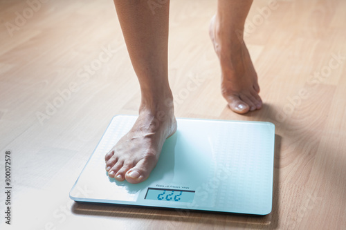 Healthy diet, fitness and weight loss concept. The legs of a young woman on the scales. Checking the weight.