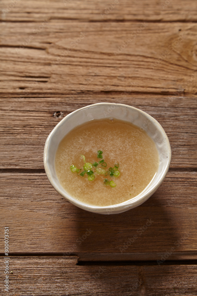 bowl of broth soup on wooden table. bowl of broth soup on wooden table.