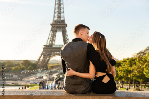 Love in Paris. Beautiful couple kissing near the Eiffel tower. Romantic date, honeymoon in Paris