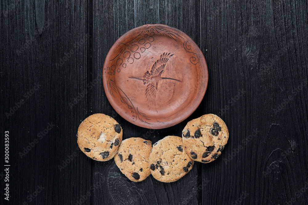 cookies on a black background with a clay plate cookies on a black background with a clay plate