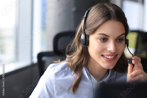 Stampa su Tela Beautiful smiling call center worker in headphones is working at modern office