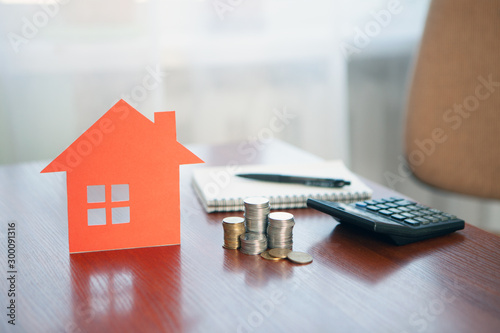 Buying and selling houses and real estate prices. Concept. Man using calculator to count rent money.