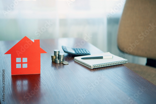Buying and selling houses and real estate prices. Concept. Man using calculator to count rent money.