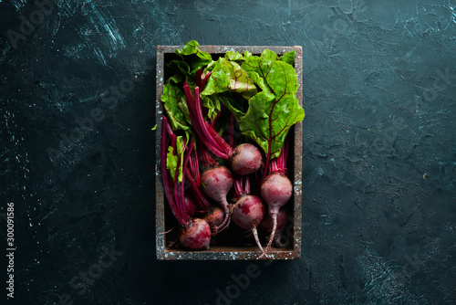 Fresh beetroot with leaves on a black stone background. Healthy food. Top view. Free space for your text.
