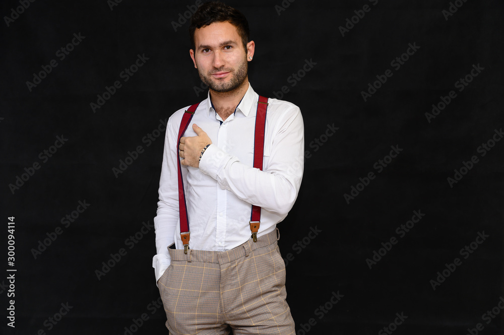 Men's fashion concept. Portrait of a handsome male model with perfect body wearing a white shirt posing on a black background. Black hair. Close Studio Shot Men's fashion concept. Portrait of a handsome male model with perfect body wearing a white shirt posing on a black background. Black hair. Close Studio Shot