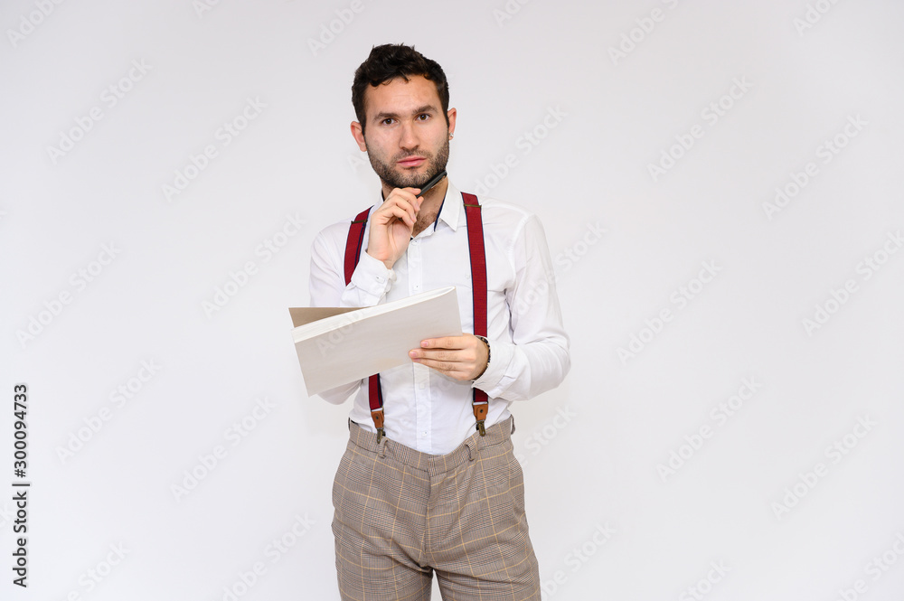 Men's fashion concept. Portrait of a handsome male model with a folder in his hands with a perfect body wearing a white shirt, posing on a white background. Black hair. Close Studio Shot Men's fashion concept. Portrait of a handsome male model with a folder in his hands with a perfect body wearing a white shirt, posing on a white background. Black hair. Close Studio Shot