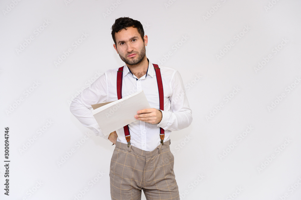 Men's fashion concept. Portrait of a handsome male model with a folder in his hands with a perfect body wearing a white shirt, posing on a white background. Black hair. Close Studio Shot Men's fashion concept. Portrait of a handsome male model with a folder in his hands with a perfect body wearing a white shirt, posing on a white background. Black hair. Close Studio Shot
