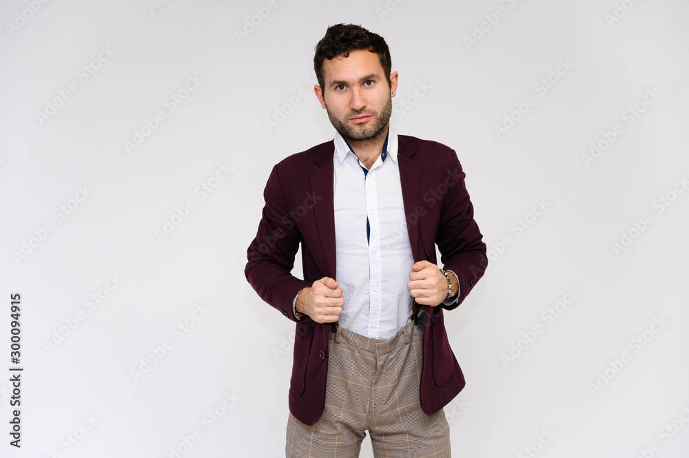 Men's fashion concept. Portrait of a handsome male model showing hands with a perfect body wearing a dark jacket, posing on a white background. Black hair. Close Studio Shot Men's fashion concept. Portrait of a handsome male model showing hands with a perfect body wearing a dark jacket, posing on a white background. Black hair. Close Studio Shot