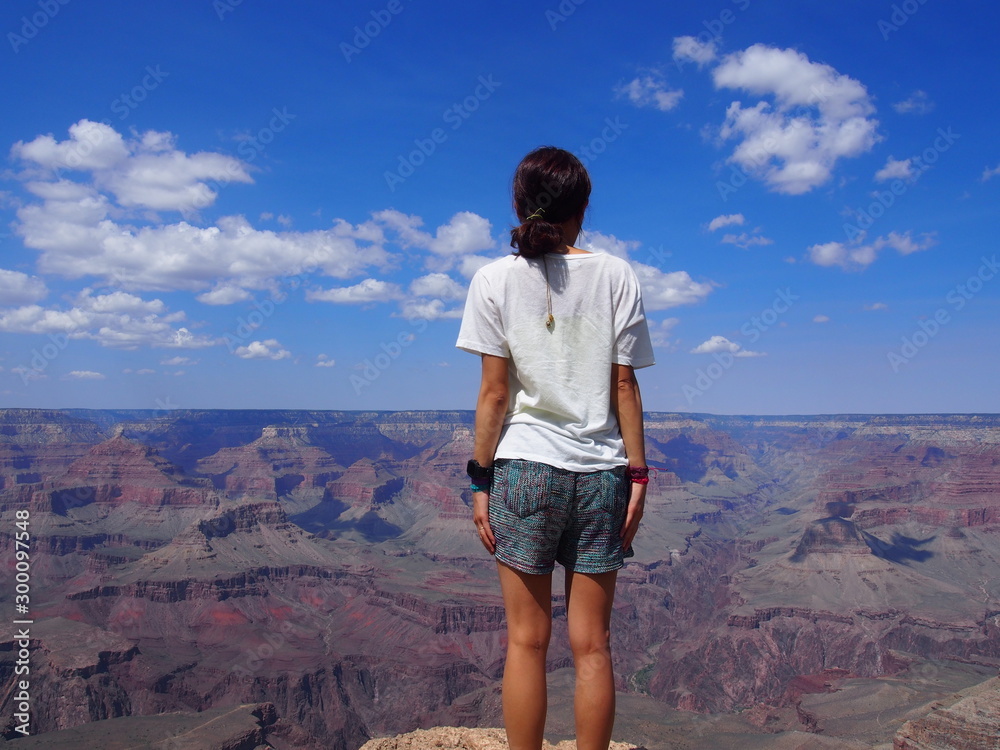 A woman gazes at the spectacular valley and stands at the edge of the Grand Canyon, Grand Canyon National Park, Arizona, USA A woman gazes at the spectacular valley and stands at the edge of the Grand Canyon, Grand Canyon National Park, Arizona, USA