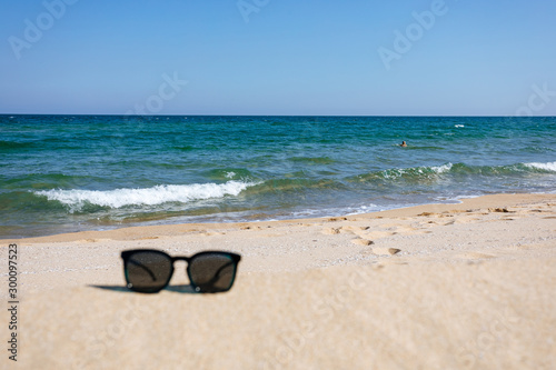 Sunglasses on sandy beach, black sea © igor_kravtsov