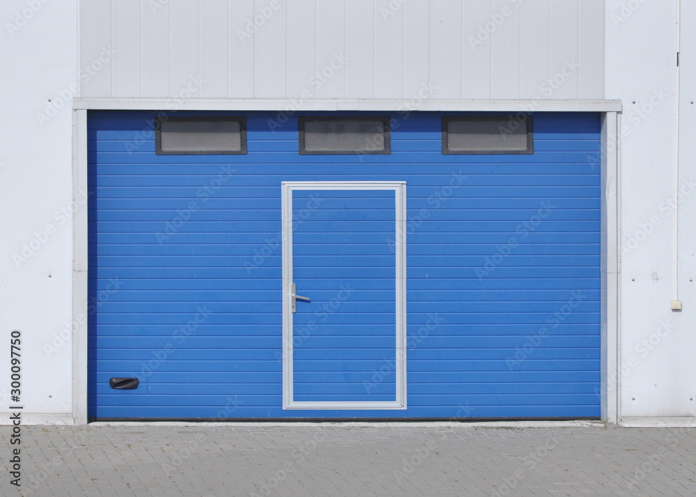Louvred gates of blue color at the entrance to the warehouse building. Louvred gates of blue color at the entrance to the warehouse building.