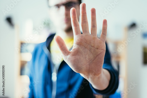 Defense or stop gesture: Male hand with stop gesture photo