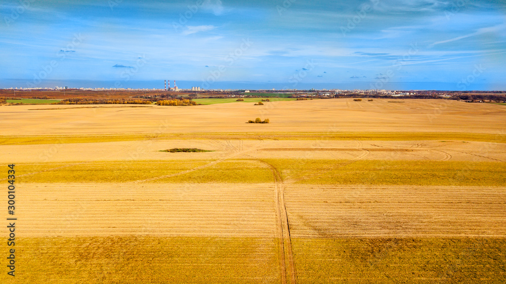 Fototapeta premium View from the field to the town in the autumn