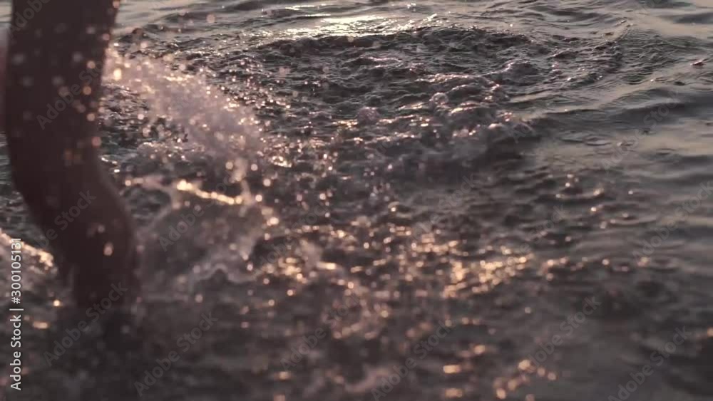 SLOW MOTION, CLOSE UP, COPY SPACE, woman runs into shallow ocean water at idyllic exotic sunrise. Carefree girl on tropical beach runs into refreshing sea at golden sunrise. SLOW MOTION, CLOSE UP, COPY SPACE, woman runs into shallow ocean water at idyllic exotic sunrise. Carefree girl on tropical beach runs into refreshing sea at golden sunrise.