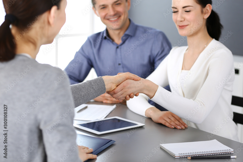 Group of business people shaking hands after discussing questions at meeting in modern office. Handshake close-up. Teamwork, partnership and agreement in business concept Group of business people shaking hands after discussing questions at meeting in modern office. Handshake close-up. Teamwork, partnership and agreement in business concept