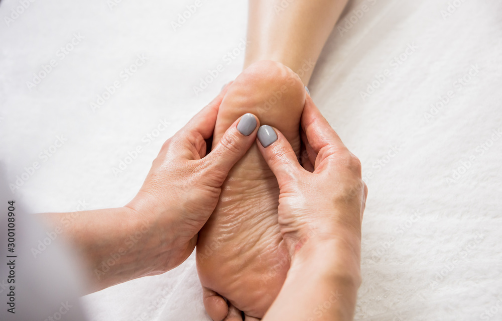 Beautiful young woman enjoying foot massage in spa salon. Cosmetology Beautiful young woman enjoying foot massage in spa salon. Cosmetology