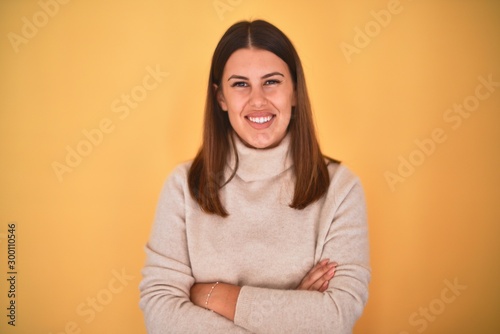 Young beautiful woman smiling happy wearing a sweater over isolated yellow background