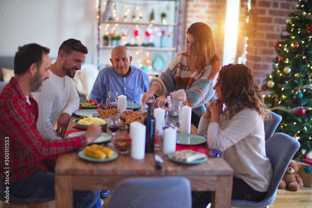 Obraz premium Beautiful family smiling happy and confident. Carving roasted turkey celebrating Christmas at home