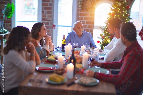 Beautiful family smiling happy and confident. Eating roasted turkey celebrating Christmas at home