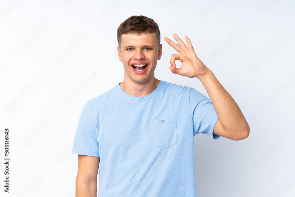 Young handsome man over isolated white background surprised and showing ok sign