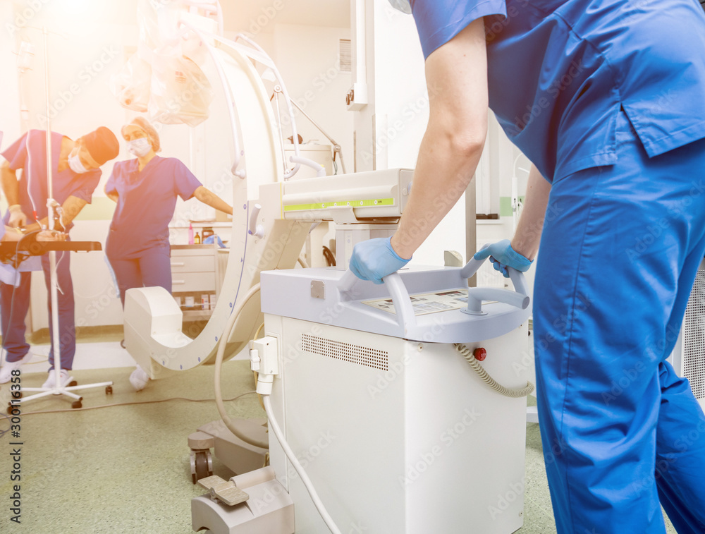 Process of trauma surgery operation. Group of surgeons in operating room with surgery x-ray equipment. Process of trauma surgery operation. Group of surgeons in operating room with surgery x-ray equipment.