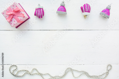Christmas background top view. Pink and red gift boxes. Coniferous branches and Christmas toys on a background of a white wooden board. New Year 2020