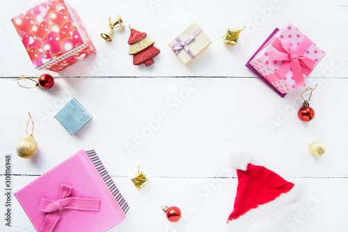 Christmas background top view. Pink and red gift boxes. Coniferous branches and Christmas toys on a background of a white wooden board. New Year 2020