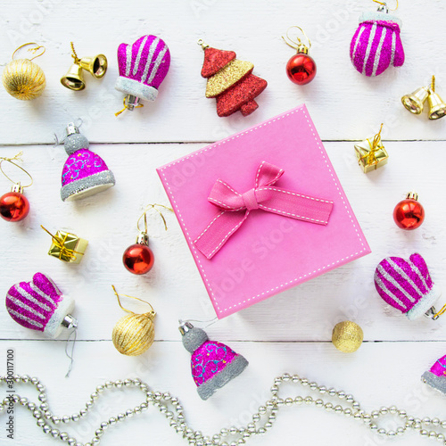 Christmas background top view. Pink and red gift boxes. Coniferous branches and Christmas toys on a background of a white wooden board. New Year 2020