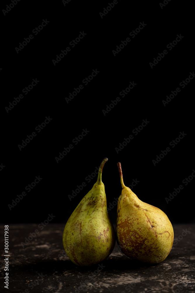 two pears in black background with copy space two pears in black background with copy space