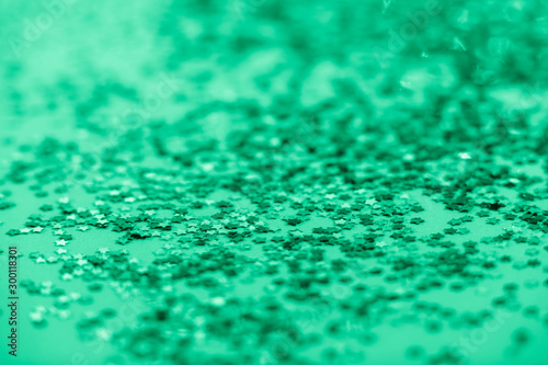 The selective focus photo of the confetti in the form of stars. Abstract textured background toned biscay green color