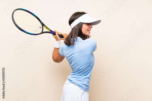 Young woman playing tennis over isolated background