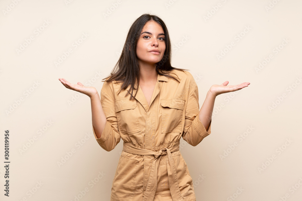 Young girl over isolated background having doubts while raising hands Young girl over isolated background having doubts while raising hands