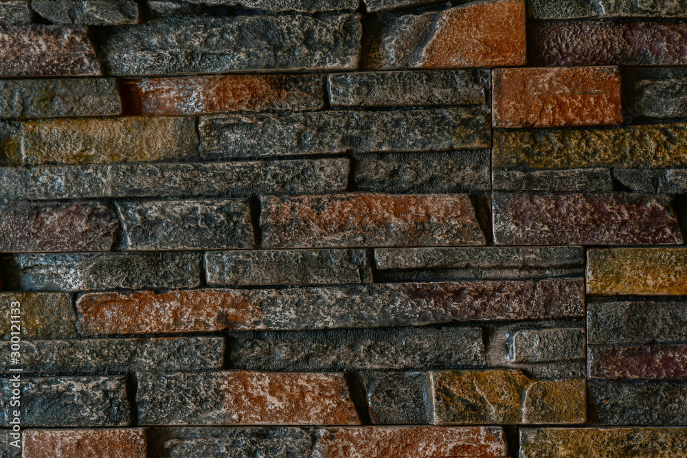 Naklejka premium Fragment of the wall of the room, lined with dark natural stone. Close up
