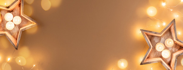 Christmas background decorations candles garland on beige background, banner