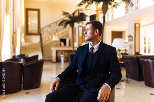 Luxury groom in suit. Businessman. The morning of the groom, bridegroom's fees. Sexy man in suit posing. Happy smiling groom newlywed. 