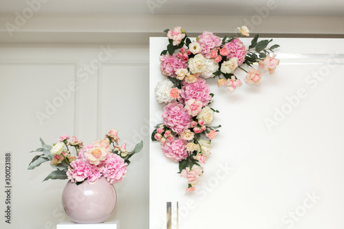 Wedding decorations. Holiday decoration vase with fresh flowers near the wedding arch. Pink roses and carnations