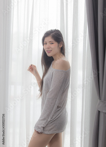Free Download Sexy beautiful woman standing by the window in the bedroom - GFXLoad