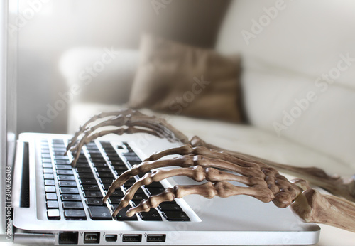 Close up of skeleton typing on laptop 