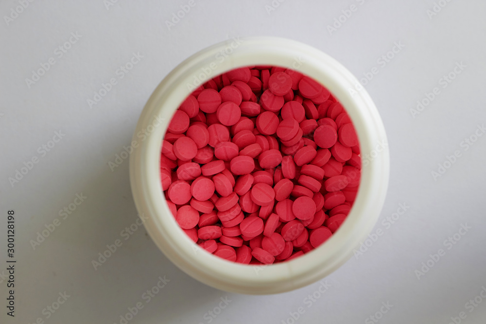 pink round tablets in white jar in medical healthcare drugstore concept,closed up pink round tablets in white jar in medical healthcare drugstore concept,closed up
