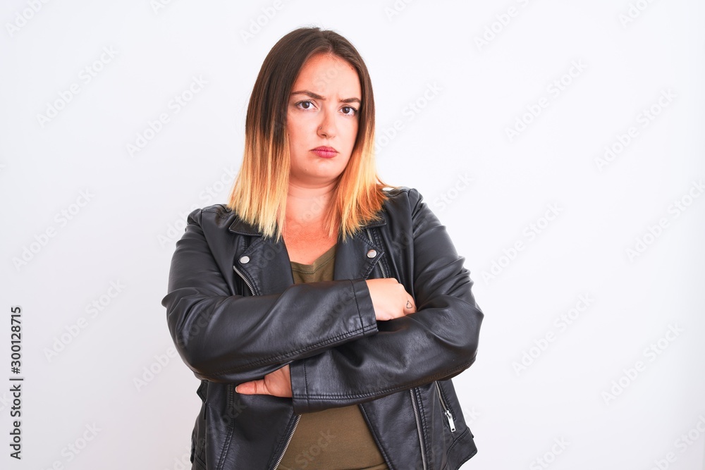 Young beautiful woman wearing t-shirt and jacket standing over isolated white background skeptic and nervous, disapproving expression on face with crossed arms. Negative person. Young beautiful woman wearing t-shirt and jacket standing over isolated white background skeptic and nervous, disapproving expression on face with crossed arms. Negative person.
