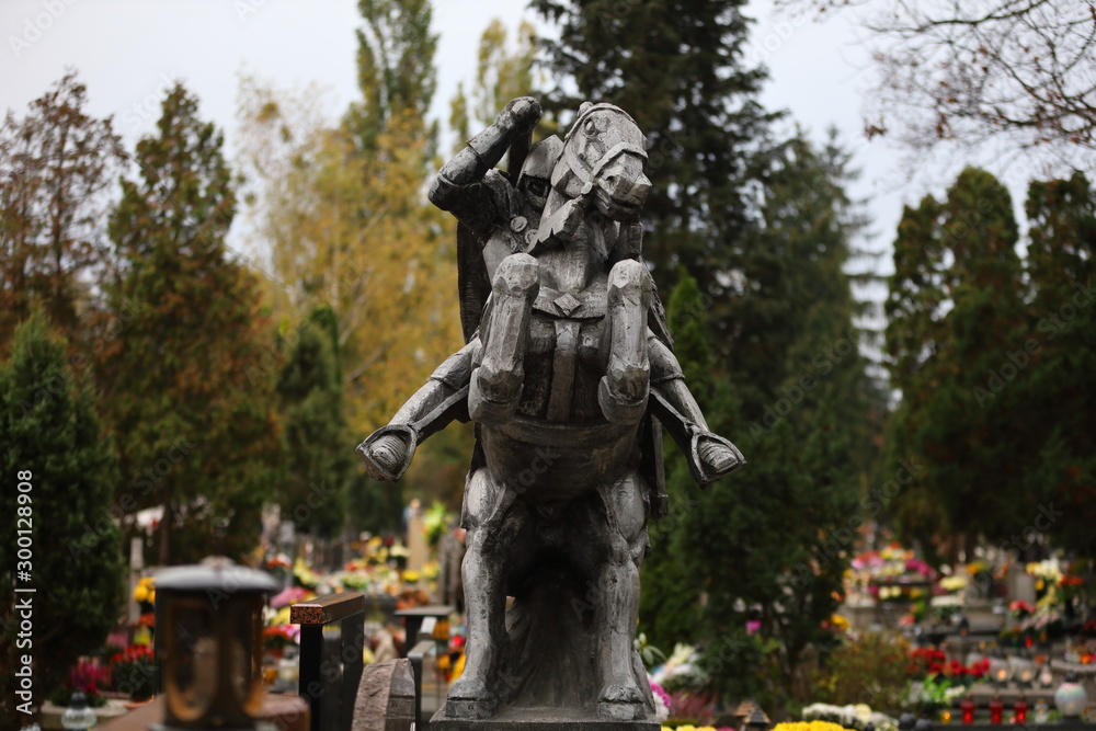 statue of a knight on a horse in a cemetery in Poland