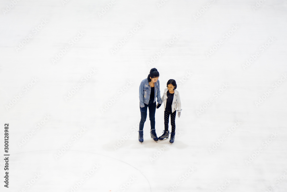 Woman and child playing ice skating Woman and child playing ice skating