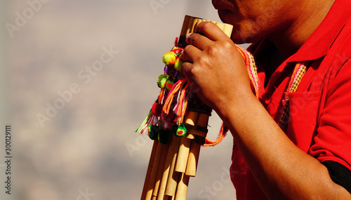 Músico indígena tocando la quena photo