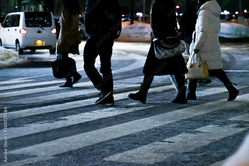 凍結した横断歩道を渡る歩行者 / 北海道札幌市の市街地 凍結した横断歩道を渡る歩行者 / 北海道札幌市の市街地